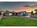 Charming single-story home featuring a well-maintained lawn and a brightly colored garage door at 8637 E Jackrabbit Rd, Scottsdale, AZ 85250