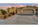 Well-maintained home exterior featuring a three-car garage, desert landscaping, and a paved driveway at 9727 E Presidio Rd, Scottsdale, AZ 85260