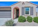 Charming single-story home featuring a tile roof, desert landscaping, covered porch and brick-trim door at 10730 W Escuda Dr, Peoria, AZ 85373