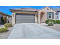 Single-story home featuring a tile roof, desert landscaping, and driveway leading to a two-car garage at 10730 W Escuda Dr, Peoria, AZ 85373
