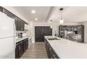 Stylish kitchen featuring dark cabinets, stainless steel appliances, a spacious counter, and attractive modern lighting at 1253 E Avila Ave, Casa Grande, AZ 85122