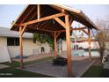 This outdoor space features a charming pergola with a fire pit and views of the sparkling pool at 1253 E Avila Ave, Casa Grande, AZ 85122