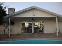 This backyard features a sparkling pool, a covered patio area, and large sliding glass doors at 1253 E Avila Ave, Casa Grande, AZ 85122