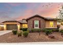 Charming single-story home featuring a stone accent wall, well-manicured landscaping, and a two-car garage at 14845 W Georgia Dr, Surprise, AZ 85379