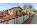 Exterior view of a single-story home with turquoise window accents, desert landscaping, and a rustic painted wood fence at 157 W Apache St, Wickenburg, AZ 85390