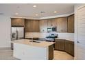 Bright kitchen features an island, stainless steel appliances, and ample cabinet space at 15818 W Kendall St, Goodyear, AZ 85338