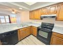 Well-lit kitchen featuring granite countertops, wooden cabinets, and modern black appliances at 2121 W Union Hills Dr # 104, Phoenix, AZ 85027