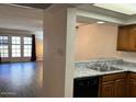 View of the open kitchen with white counters, a stainless sink, and a view of the living area at 2121 W Union Hills Dr # 104, Phoenix, AZ 85027