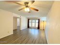 Spacious living room with modern ceiling fan, neutral paint, and a large sliding glass door to the back at 2121 W Union Hills Dr # 104, Phoenix, AZ 85027