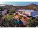 Gorgeous backyard showcasing a sparkling pool, lush landscaping, a patio with chairs, and mountain views at 22500 N 97Th St, Scottsdale, AZ 85255