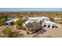 Aerial view of a modern home highlighting the desert landscape and a private driveway with a gate at 22500 N 97Th St, Scottsdale, AZ 85255