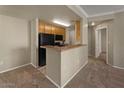 Practical kitchen featuring essential appliances and a cozy breakfast bar opening to the living area at 2992 N Miller Rd # 103, Scottsdale, AZ 85251