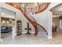 Elegant foyer with a grand curved staircase and tile flooring at 3713 E Cat Balue Dr, Phoenix, AZ 85050