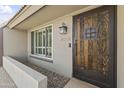 Close-up of a home's entry featuring a decorative wood door and adjacent shuttered window at 4001 E Cannon Dr, Phoenix, AZ 85028