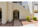 Exterior of condo entrance featuring an archway and a well-maintained walkway and small shrubs at 4730 W Northern Ave # 1158, Glendale, AZ 85301