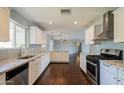 Modern kitchen featuring white cabinets, granite countertops, stainless steel appliances, and hardwood flooring at 6820 E Pinchot Ave, Scottsdale, AZ 85251