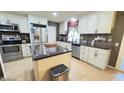 Well-equipped kitchen with stainless steel appliances, granite countertops, and white cabinetry at 9814 W Shasta Dr, Sun City, AZ 85351