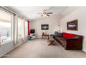 Bright living room featuring neutral walls, carpet, a ceiling fan, large windows and comfortable furniture at 1339 E Silverbrush Trl, Casa Grande, AZ 85122