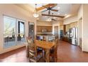 Bright dining area adjacent to the kitchen, featuring a wooden table, tile floors, and large windows with views at 16835 E Skinner Dr, Rio Verde, AZ 85263