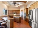 Modern kitchen with granite countertops, stainless steel appliances, wooden cabinetry, a center island, and tile flooring at 16835 E Skinner Dr, Rio Verde, AZ 85263