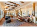 Spacious living room with beamed ceilings, tile flooring, and a seamless transition to the kitchen and dining area at 16835 E Skinner Dr, Rio Verde, AZ 85263