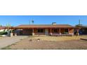 Single-story home featuring a covered front porch, carport, and fresh landscaping at 2144 W Joan De Arc Ave, Phoenix, AZ 85029