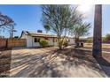 A lovely single-story house boasts a large driveway and beautiful desert landscaping, enhanced by a mature tree at 2205 N 22Nd St, Phoenix, AZ 85006