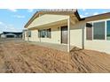 Inviting front porch with a brown front door, cream-colored siding, and contrasting brown shutters and trim at 2744 S 357Th Dr, Tonopah, AZ 85354