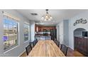 Open dining area with a large wood table, tile flooring, and bright windows at 2983 E Harrison St, Gilbert, AZ 85295