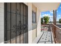 Inviting condo entry with secure metal gate, brick facade, and private balcony overlooking a pool at 3737 E Turney Ave # 206, Phoenix, AZ 85018