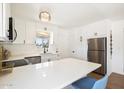 Well-lit kitchen with white cabinets, stainless steel appliances and large quartz countertop island at 3737 E Turney Ave # 206, Phoenix, AZ 85018