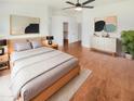 Serene main bedroom featuring a large bed, soft decor, a ceiling fan, and a view to the walk-in closet at 4216 S 100Th Dr, Tolleson, AZ 85353