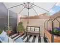 Outdoor patio with comfortable seating, planters, and an umbrella for shade at 42424 N Gavilan Peak Pkwy # 30104, Anthem, AZ 85086