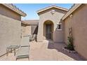 Inviting courtyard with brick flooring, seating, and a charming arched entryway into the home at 42808 W Whimsical Dr, Maricopa, AZ 85138