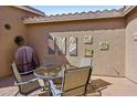 Cozy outdoor patio with comfortable seating, a grill, and decorative wall art for outdoor enjoyment at 42808 W Whimsical Dr, Maricopa, AZ 85138