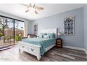 Bright bedroom with a ceiling fan, plush bedding, and a sliding glass door to the patio at 705 W Queen Creek Rd # 1059, Chandler, AZ 85248