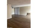 Bright living room featuring new hardwood floors, a modern ceiling fan, and a sliding glass door at 730 E Dobbins Rd, Phoenix, AZ 85042