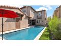 Inviting pool with backyard views, a red umbrella, and lush landscaping at 9282 E Desert Vw, Scottsdale, AZ 85255