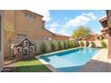 A backyard pool with turf and privacy landscaping on a sunny day at 9282 E Desert Vw, Scottsdale, AZ 85255