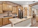 Warm kitchen with brick backsplash, central island, stainless steel appliances, and natural wood accents at 103 W Tanya Rd, Phoenix, AZ 85086