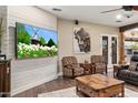 Cozy living room featuring hardwood floors, a mounted television, and comfortable armchairs at 103 W Tanya Rd, Phoenix, AZ 85086