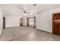 Bright living room features tile and carpet flooring, a ceiling fan, and a large window at 1320 W Mariposa St, Phoenix, AZ 85013