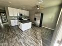 Well-lit kitchen with white cabinets, stainless appliances, and a center island for modern functionality at 14024 W Noble Cir, Casa Grande, AZ 85122