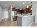 Bright kitchen featuring a stainless steel refrigerator, dark cabinets, white countertops, and a stylish backsplash at 14200 W Village Pkwy # 107, Litchfield Park, AZ 85340