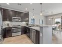 Modern kitchen featuring stainless steel appliances, dark cabinets, a stylish backsplash, and pendant lighting at 14200 W Village Pkwy # 107, Litchfield Park, AZ 85340