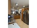 View of the kitchen, featuring wood cabinets, granite counters, stainless appliances, and tile floors at 1606 S 226Th Dr, Buckeye, AZ 85326