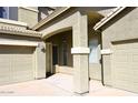 Inviting front entrance with covered porch, columns, and a three car garage on a stucco home at 1765 N Agave St, Casa Grande, AZ 85122