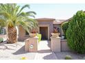 Well manicured landscaping adorns the walkway to this tan home at 19437 N Guardian Ln, Surprise, AZ 85387