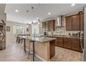 Open kitchen featuring a large island with bar seating, modern appliances, and stylish pendant lighting at 20646 W Delaney Dr, Buckeye, AZ 85396