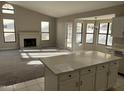 Bright living room with a fireplace, large windows, neutral walls and carpet, and adjoins the kitchen at 3703 N Wintergreen Way, Avondale, AZ 85392